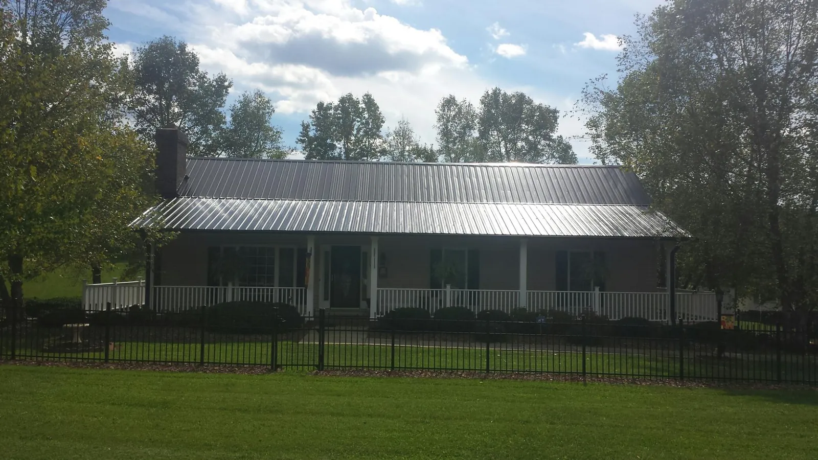 Gray metal roof on a brick ranch with a full width front porch — Gutter Guard Installation work by our crew in Westfield